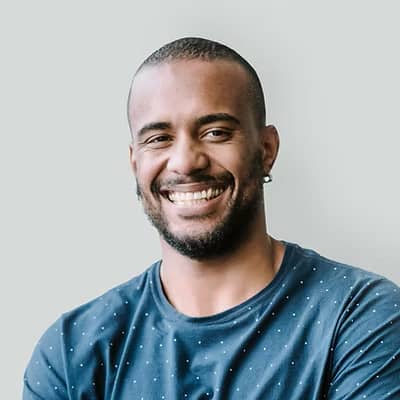 Headshot of testimonial man. He is smiling and looking at the camera, he is wearing a T-shirt and looks casual.